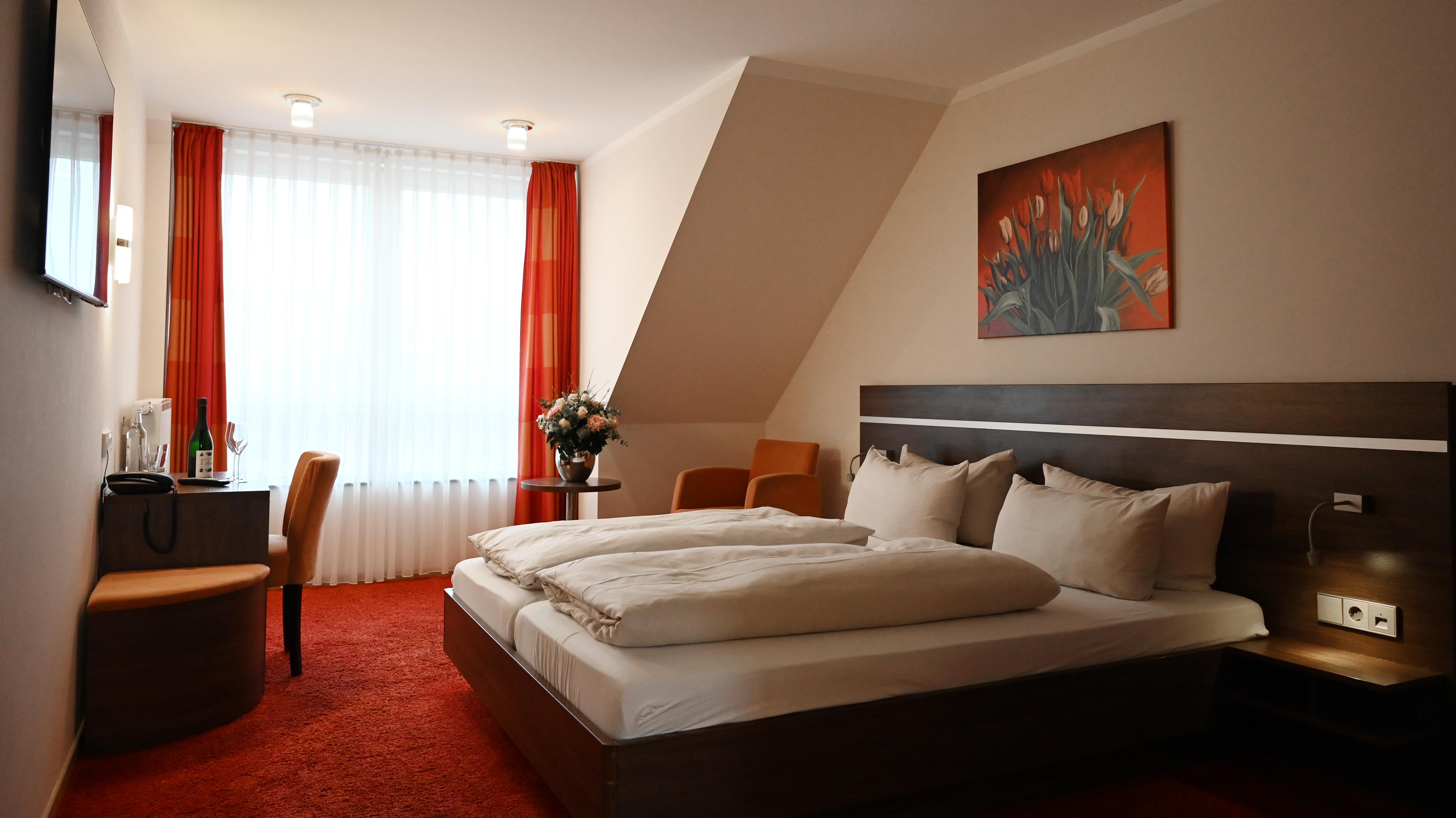 Modernes Hotelzimmer im Hotel Schmidt am Markt in Meppen. Komfortable Ausstattung, zentrale Lage am Marktplatz und ideal für Geschäfts- oder Urlaubsreisen. Jetzt direkt buchen & sparen.